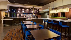 A modern bar area with multiple seating options, a counter with a beverage display, and a kitchen in the background. - Modern Houston Suite with 2 Double Beds, Pool & Prime Location, 2 Units (Houston)