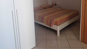 Un dormitori amb llit, un armari i una porta.