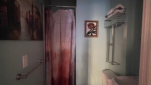 A narrow bathroom with a shower curtain, a toilet, and a sink. - Delightful 1-bedroom suit in boutique guesthouse with AC in vibrant New York (New York)