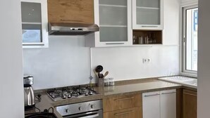 A modern kitchen with a gas stove, oven, and built-in cabinets. - Gammarth Blue Pearl (La Marsa)
