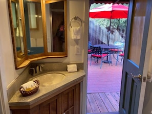 A bathroom with a sink, mirror, and wooden cabinets. - Arches - Olive Grove Cottage (Sonoma)