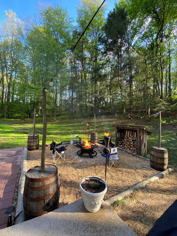 An outdoor patio with a fire pit, seating, and rustic decor.