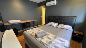 Une chambre d’hôtel moderne avec un grand lit, un bureau, une chaise et une petite table.