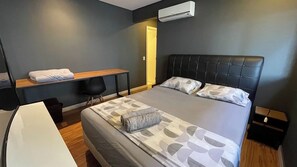 Ein modernes Hotelzimmer mit einem großen Bett, einem Schreibtisch, einem Stuhl und einem kleinen Tisch.