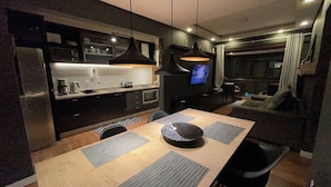 Une cuisine moderne avec un coin repas, un téléviseur et un canapé.