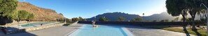 En pool med bjergudsigt, stenvægge og træer.