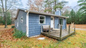 A small house with a porch, a door, and a window. - Cabin #7 Wishing Star (Iosco County)