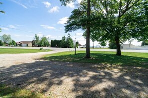 A gravel parking area with trees and a clear sky. - Cabin #2 Water's Edge (Iosco County)