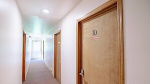 Ein Korridor mit Holztüren, eine davon mit der Nummer 10 und einem Rauchverbot-Schild.