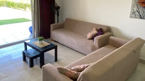 Ein Wohnzimmer mit einer Couch, einem Couchtisch und einem Gemälde an der Wand.