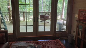 A wooden-framed room with a large sliding glass door leading to an outdoor deck.