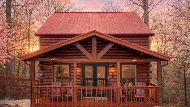 A log cabin with a porch, two doors, and a small outdoor seating area. - Location, Smoky Mountain View, Hot Tub, Games! (Sevierville)