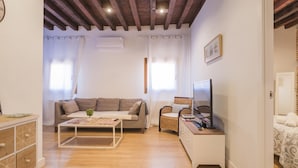 Uma sala de estar com sofá, mesa de centro, televisão e armário.