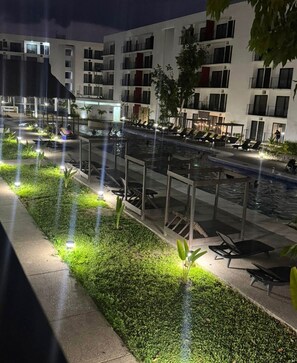 A nighttime view of a hotel with a swimming pool, lounge chairs, and a well-lit garden area. - Close to the beautiful beaches of Punta de Mita and 10 minutes from the sea of Bucerias. (Tondoroque)