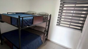 Een stapelbed met een onderste bed en een raam met zonwering.