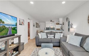 A living room with a grey sofa, a coffee table, and a TV on a stand. - Oceanfront Escape Shore Dr Condo Balcony (Myrtle Beach)