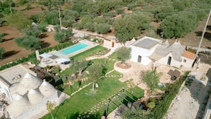 Ein Wohnhaus mit Schwimmbad, Garten und einem Steinhaus.