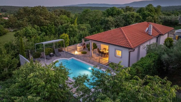 Ein Haus mit Schwimmbad, Terrasse und Blick auf die umliegende Landschaft.