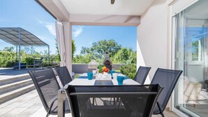 Ein Balkon mit Tisch, Stühlen und einem Grill.
