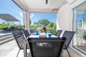 Ein Balkon mit Tisch, Stühlen und einem Grill.