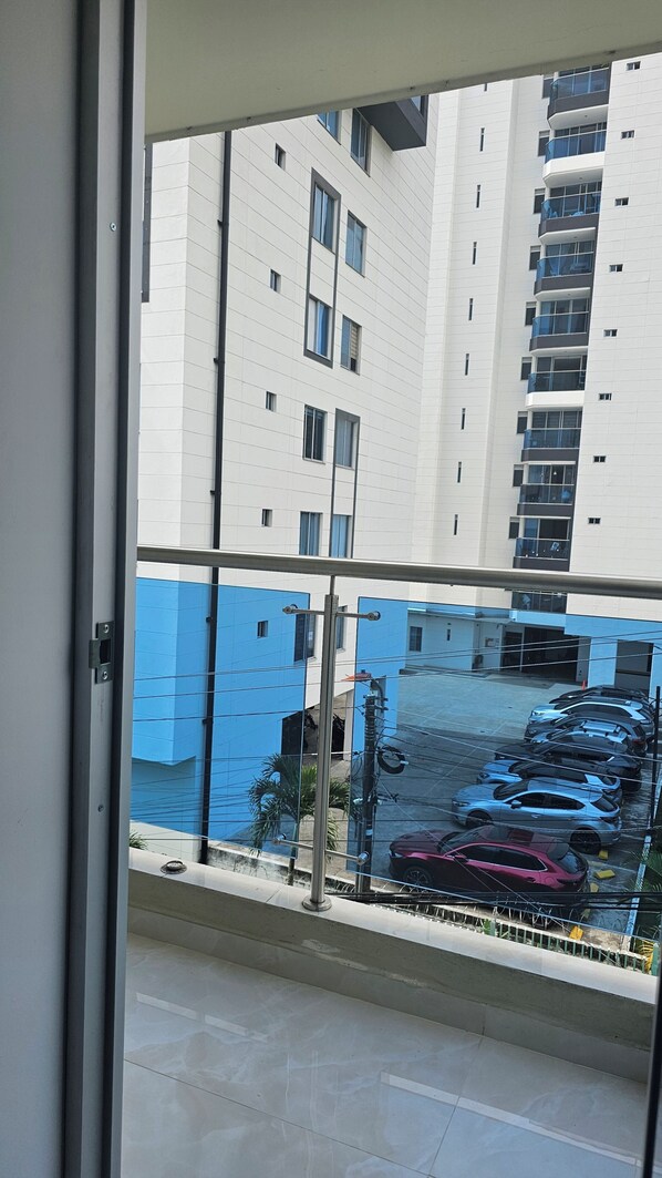 A view through a window of a multi-story building with a parking area below.