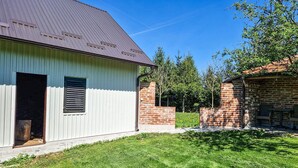 Ein eingeschossiges Gebäude mit einer Metallbedeckung, einem Ziegelanbau und einem Rasen.