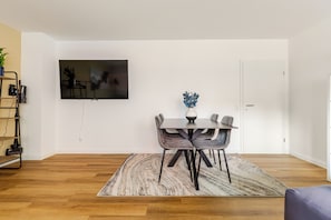A modern dining area with a table, chairs, a rug, and a television mounted on the wall. - ★Koblenz City Studio I Near main station & center vacation apartment★ (Koblenz)