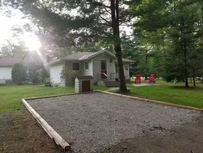 A house with a front porch, a small deck, and a gravel area in front. - Secluded Forest Haven | Hot Tub | 5 Min to Beach (Innisfil)