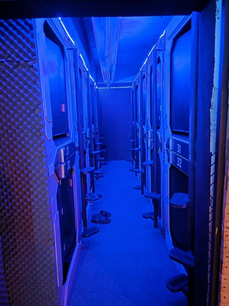 A narrow corridor with bunk beds, each marked with a number.