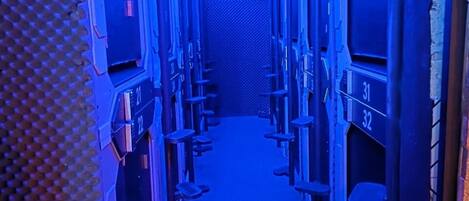 A narrow corridor with bunk beds, each marked with a number.