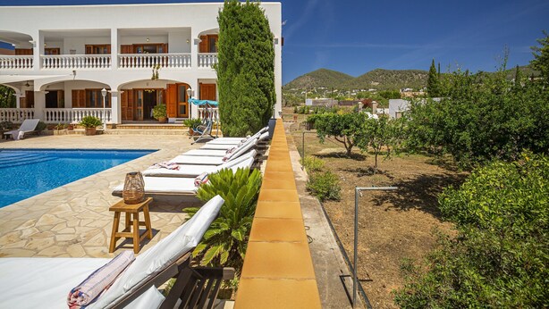 A hotel with a swimming pool, sun loungers, and a view of the surrounding landscape. - Chic 12-guest Villa With Pool in Ibiza (Santa Eulalia del Rio)