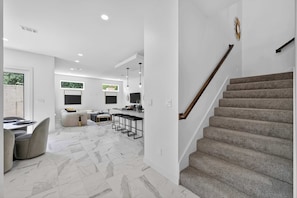 Een modern interieur met een trap, een eethoek en een keuken.