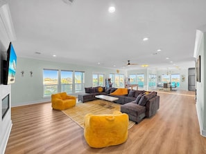 Un espacio habitable amplio con un gran sofá, sillones de peluche amarillos y una mesa de comedor.