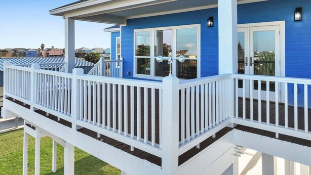 A blue house with a white porch and deck. - Serene 4-bedroom house with AC in Bolivar Peninsula (Bolivar Peninsula)