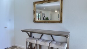 Ein Zimmer mit einer hölzernen Bank, einem Spiegel und einer Tür.
