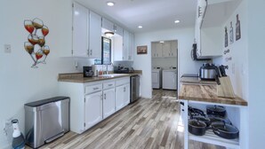Eine moderne Küche mit weißen Schränken, einer Holz Arbeitsplatte und einem eingebauten Backofen.