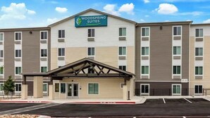 A multi-story hotel with a sign reading "WOODSPRING SUITES" above the entrance. - Budget-Conscious Suite Near Top Austin Spots – Full Amenities for Long Stays (Austin)