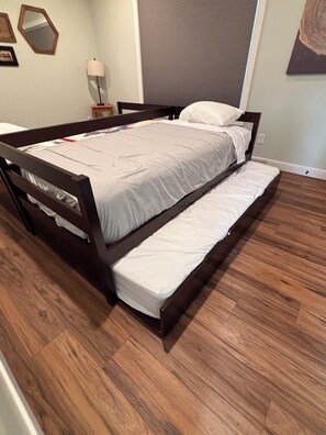 A double bed with a wooden frame, a grey mattress, and a white pillow. - Brand New 3-Bedroom Lakefront Home with PICKLEBALL and PONTOON rental option (Cumberland)