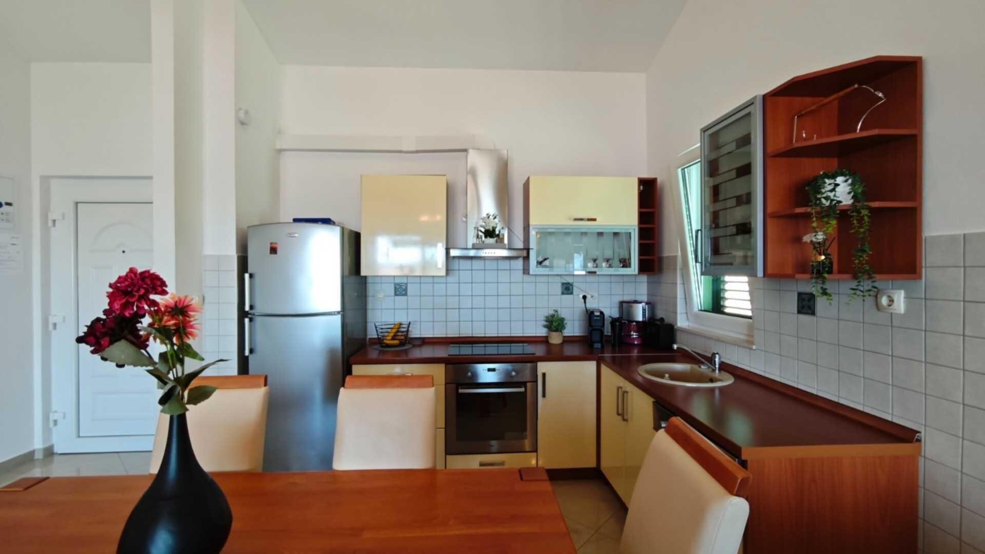 Una cocina compacta con refrigerador, horno y lavaplatos.