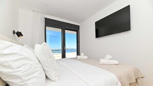 A bedroom with a bed, a TV, a window with a view, and a door. - Luxury Villa Oasis with pool and jacuzzi near beach (Trogir)