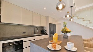 A modern kitchen with a central island, a built-in oven, and a coffee machine. - Luxury Villa Oasis with pool and jacuzzi near beach (Trogir)