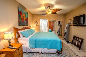A hotel room with a bed, a ceiling fan, a TV, and a painting on the wall. - Sonoran Spa W102 Ground Floor 2BR/2ba (Puerto Peñasco)