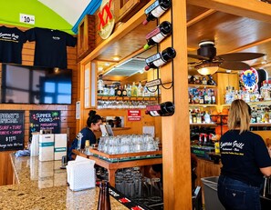 Eine Bar mit Holzvertäfelung, einer Kreidetafel als Speisekarte und einer Auswahl an Spirituosen.