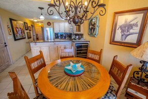 A dining area with a round table, chairs, and a chandelier. - Sonoran Spa W102 Ground Floor 2BR/2ba (Puerto Peñasco)