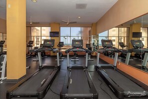 A gym with treadmills, mirrors, and a view of the ocean. - Sonoran Spa W102 Ground Floor 2BR/2ba (Puerto Peñasco)