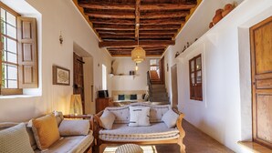 A cozy living room with a sofa, a coffee table, and a hanging light fixture. - Can Miguel, Private Ibiza Retreat (Santa Eulalia del Rio)