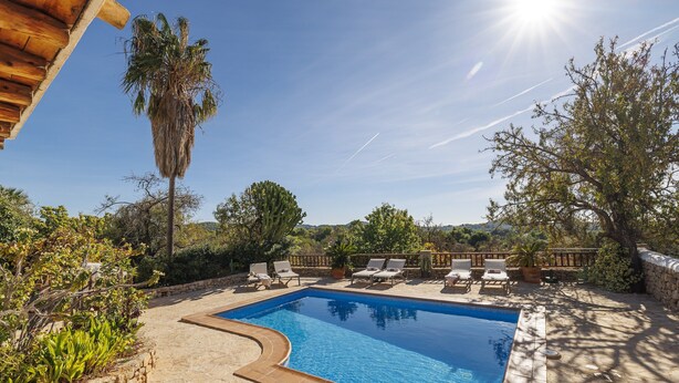 A rectangular pool with a tiled edge, surrounded by lounge chairs and a stone wall. - Can Miguel, Private Ibiza Retreat (Santa Eulalia del Rio)