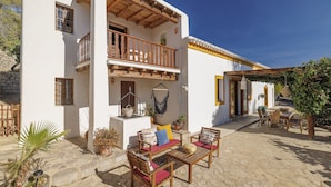 A white building with a balcony, outdoor seating, and potted plants. - Can Miguel, Private Ibiza Retreat (Santa Eulalia del Rio)