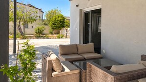 An outdoor patio with wicker furniture, a glass table, and a sliding glass door leading to a covered area. - 1 bedroom cozy apartment in Vir (Vir)