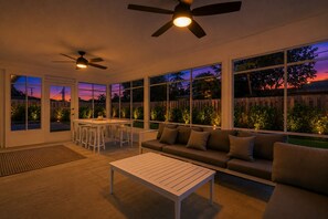 A sunroom with a dining area, a sofa, and a ceiling fan. - The Putting Palm- 4BR/2BA w/ Putting Green (Boynton Beach)